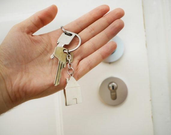 Hand holding keys to a door