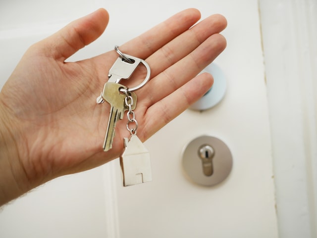 Hand holding keys to a door