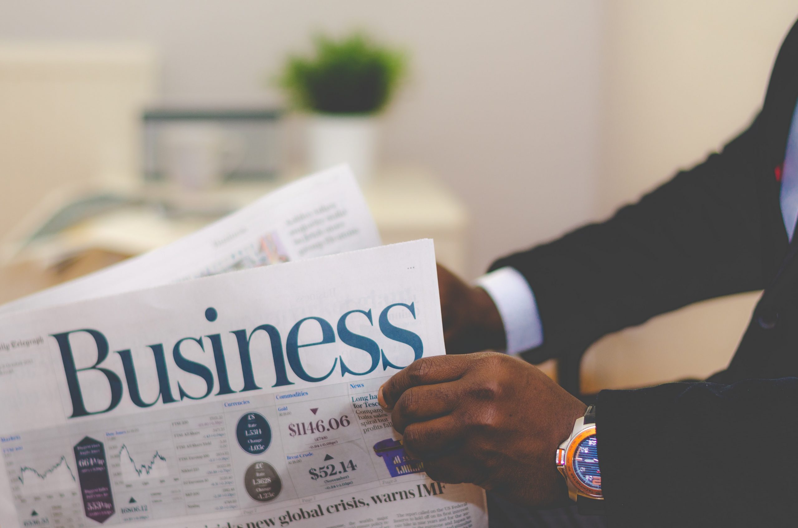 person reading business finance section of newspaper