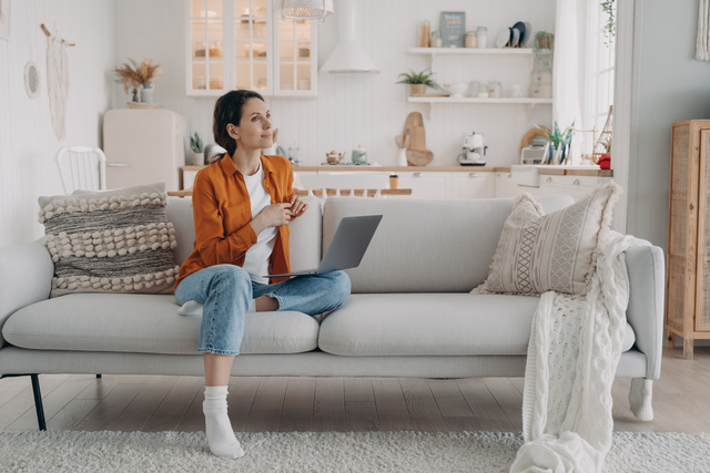 Person resting with laptop on knee, contemplating