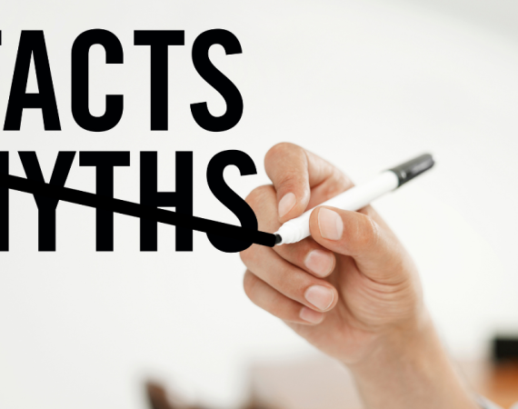 Text "Facts" and "Myths". Hand holding pen crossing "Myth" out.