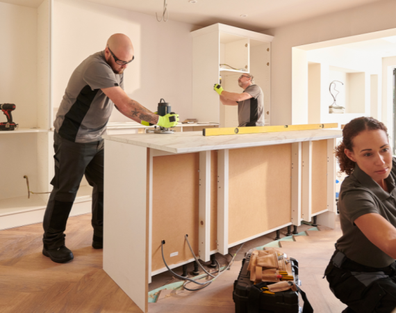 Three tradespeople renovating kitchen.