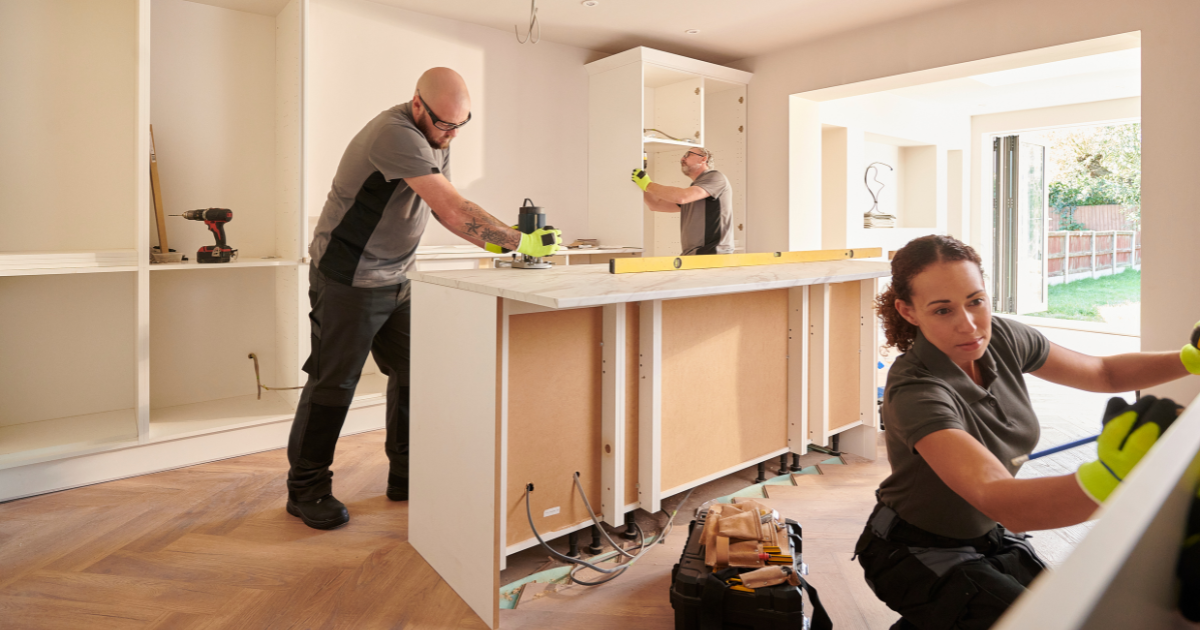 Three tradespeople renovating kitchen.